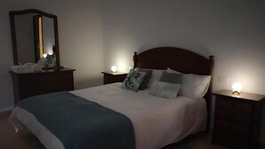 A bedroom with a bed, bedside tables, a mirror, and a nightstand with a lamp. - Blue Views (Charco Azul)
