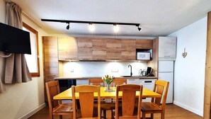 A compact kitchen with wooden cabinets, a microwave, and a coffee maker on the counter.