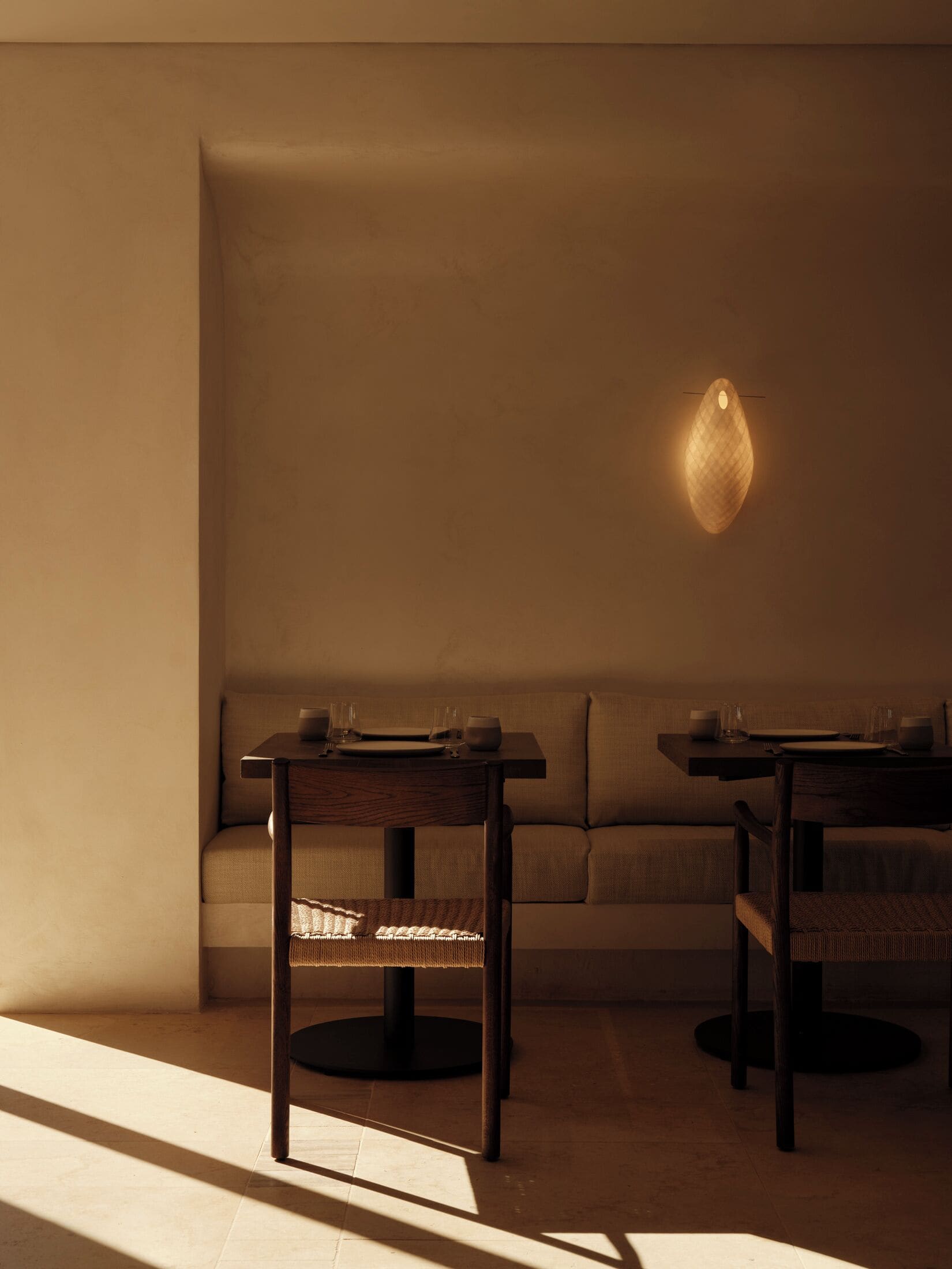A dimly lit room with two tables and a sofa.