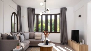 A modern living room with a sectional sofa, a coffee table, and a TV on a wooden cabinet.