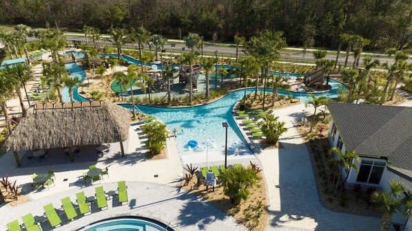 A resort with multiple swimming pools, palm trees, and lounge areas.