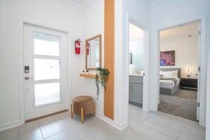A hotel room with a bed, bedside table, and a window.