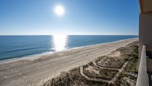 A beach with a clear sky and the sun shining.