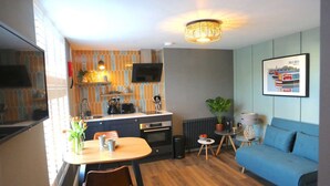 Un espace de vie compact comprenant un coin cuisine, un coin repas et un canapé.