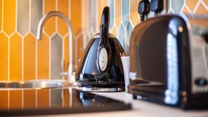Une cuisine équipée d’une bouilloire et d’un grille-pain posés sur le plan de travail.