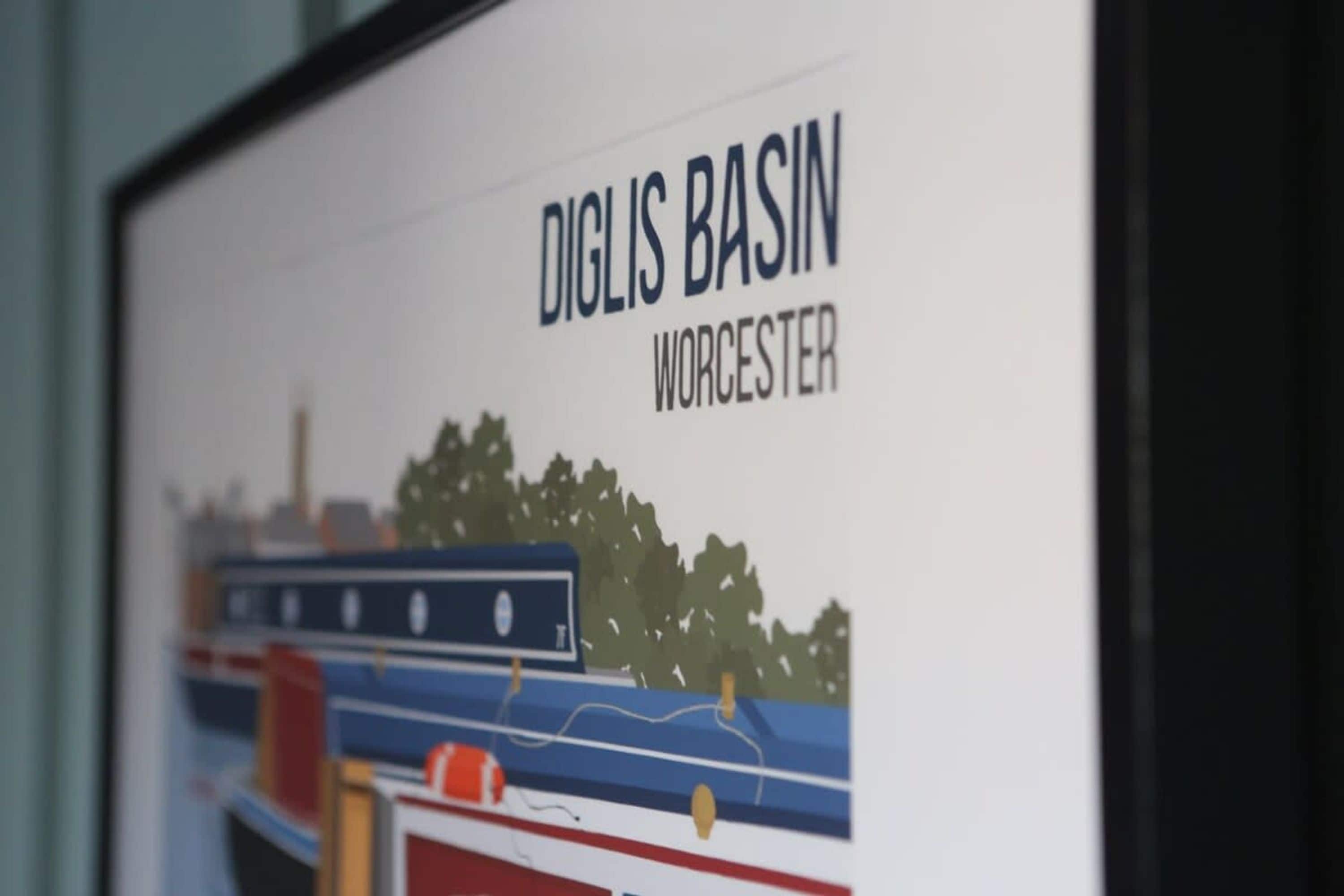 A framed picture of a river scene with boats and trees, labeled "DIGLIS BASIN WORCESTER".