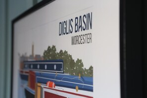 Une photographie encadrée représentant une scène de rivière avec des bateaux et des arbres, portant la légende « DIGLIS BASIN WORCESTER ».