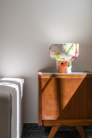 A wooden cabinet with a floral-patterned vase on top.