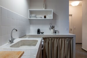 Une salle de bain moderne avec un grand lavabo, un miroir et une étagère au-dessus du lavabo.