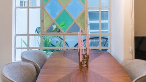 Un espace repas comprenant une table, des chaises, un vitrail et une lampe fixée au mur.
