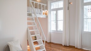 Una escalera con barandillas blancas que conduce a un dormitorio.