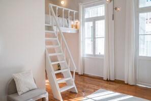 A staircase with white railings leading to a bedroom.