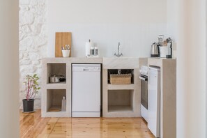 A compact kitchen with a dishwasher, a built-in oven, and a sink.