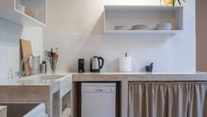 A modern kitchen with a dishwasher, a coffee maker, and a knife block. - Charlie – Timeless Charm & Modern Comfort (Athens)