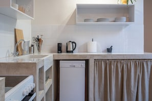 A modern kitchen with a dishwasher, a coffee maker, and a knife block. - Charlie – Timeless Charm & Modern Comfort (Athens)