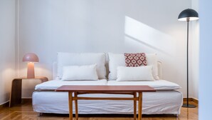 Une chambre à coucher avec un lit, une table de chevet, une lampe de chevet et une lampe sur pied.