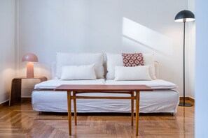 Une chambre à coucher avec un lit, une table de chevet, une lampe de chevet et une lampe sur pied.