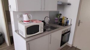 A compact kitchenette with a microwave, sink, and oven. - Le Port - Cosy studio perfectly located (Nice)