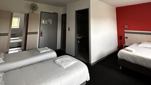 A hotel room with two beds, a red accent wall, a bathroom with a sink, and a door leading to another room. - L2R La Ferté-sous-Jouarre (La Ferte-sous-Jouarre)