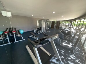 A gym with treadmills, weight machines, and exercise balls.