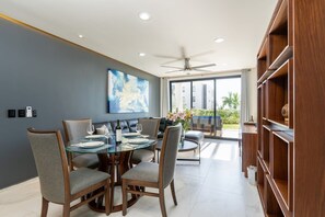 A modern dining area with a glass table, grey upholstered chairs, and a ceiling fan. - Beach Access, 4 Beds, 2 Bedroom, 2 Bath Quadrant 4107 (Bucerías)
