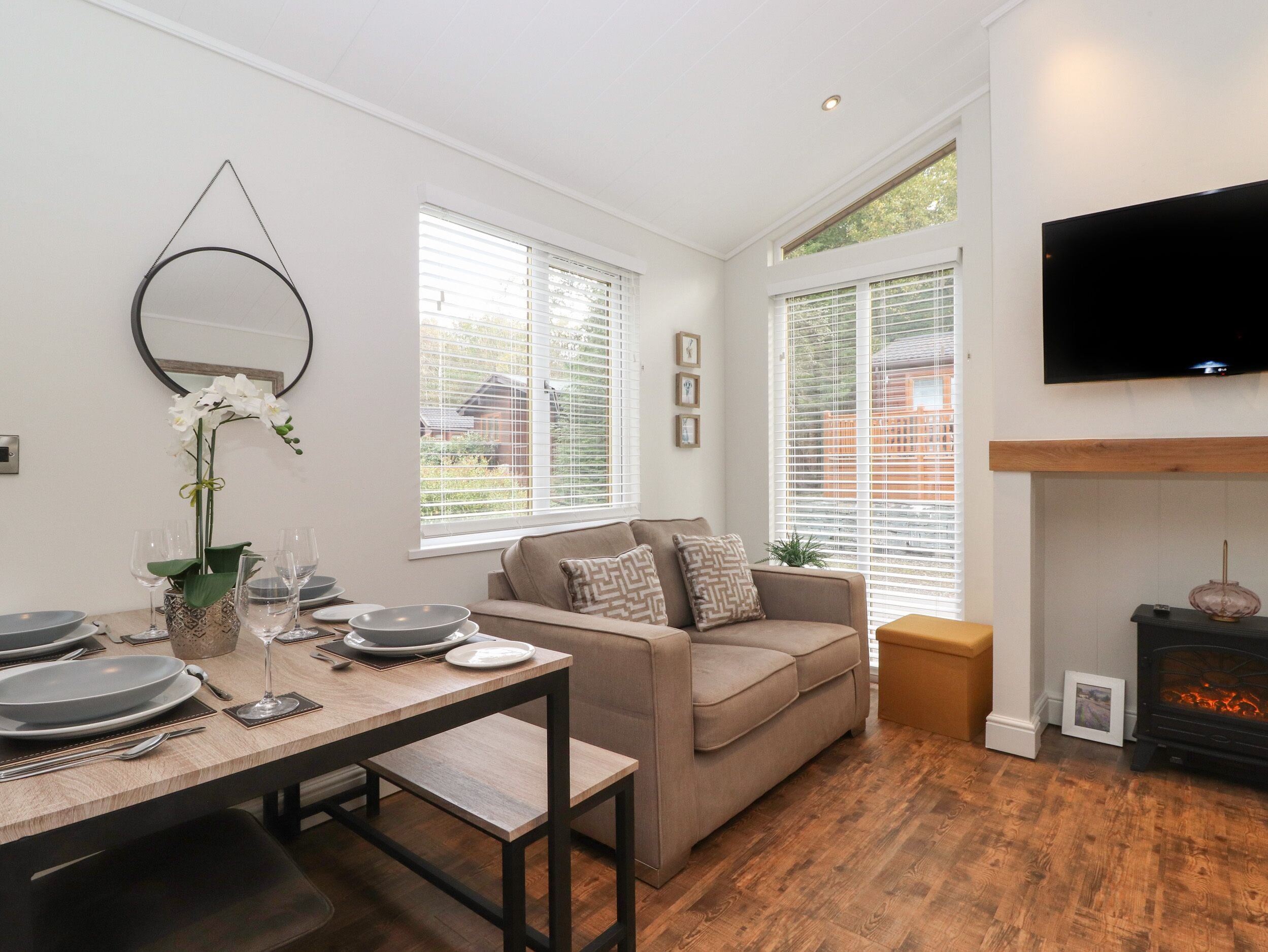 A modern living room with a sofa, dining table, and fireplace.