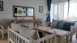 Een klassiek ingerichte woonkamer met een zithoek, een eettafel en een grote spiegel.