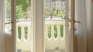 An open door with a view of a balcony and buildings in the background. - Hotel Heluan (Karlovy Vary)