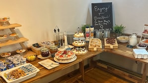A breakfast buffet with various food items and a chalkboard sign. - Hotel Heluan (Karlovy Vary)