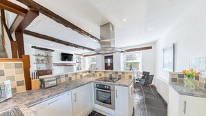 A spacious kitchen with granite countertops, white cabinetry, and a built-in oven. - Mill Cottage - sleeps 2, dog friendly, peaceful with parking (Windermere)