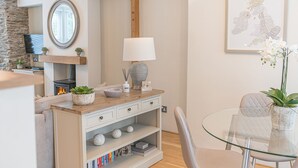 A modern living room with a fireplace, a glass table, and a comfortable seating area. - Pottery Gate - sleeps 4 in modern dog friendly cottage with parking and new bathroom (Bowness-on-Windermere)