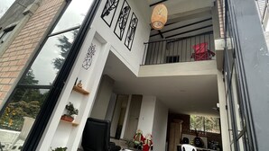 A modern interior with a glass ceiling, black furniture, and potted plants. - Beautiful villa overlooking the forest + jacuzzi (Guarne)