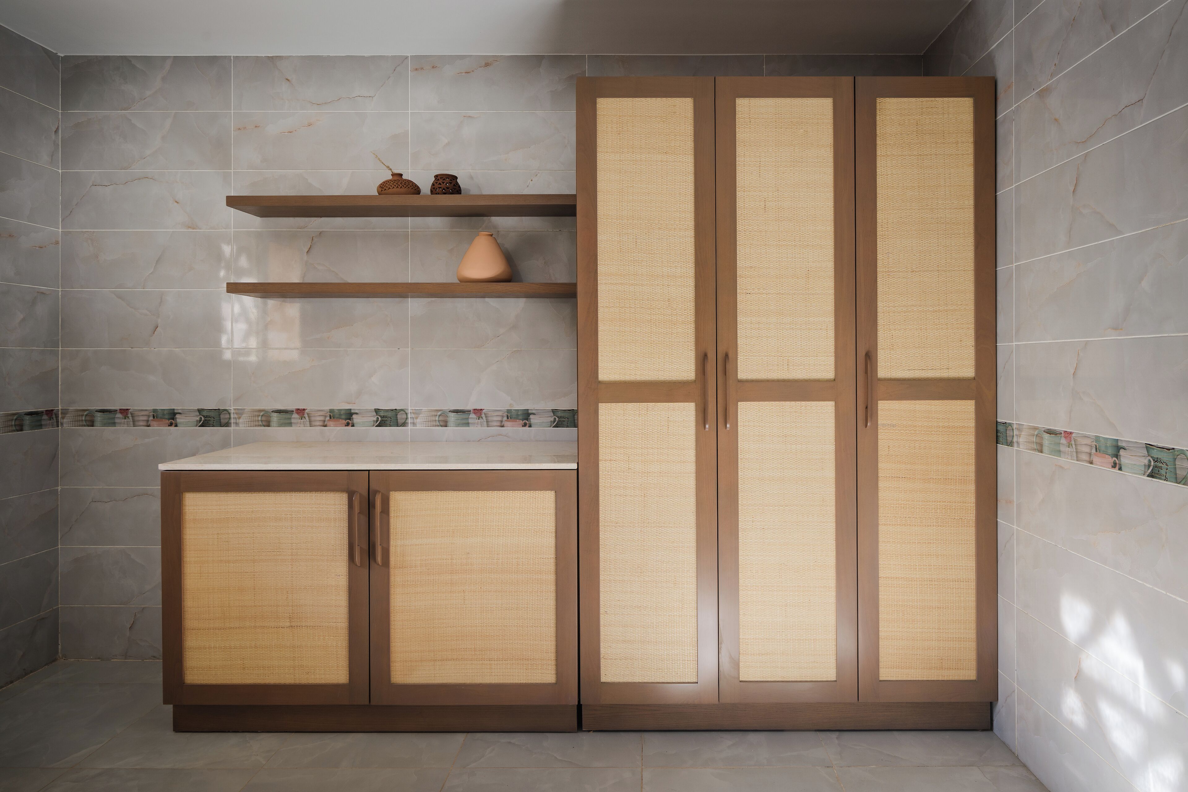 Une cuisine avec un meuble en bois et une étagère ornée d’objets décoratifs.