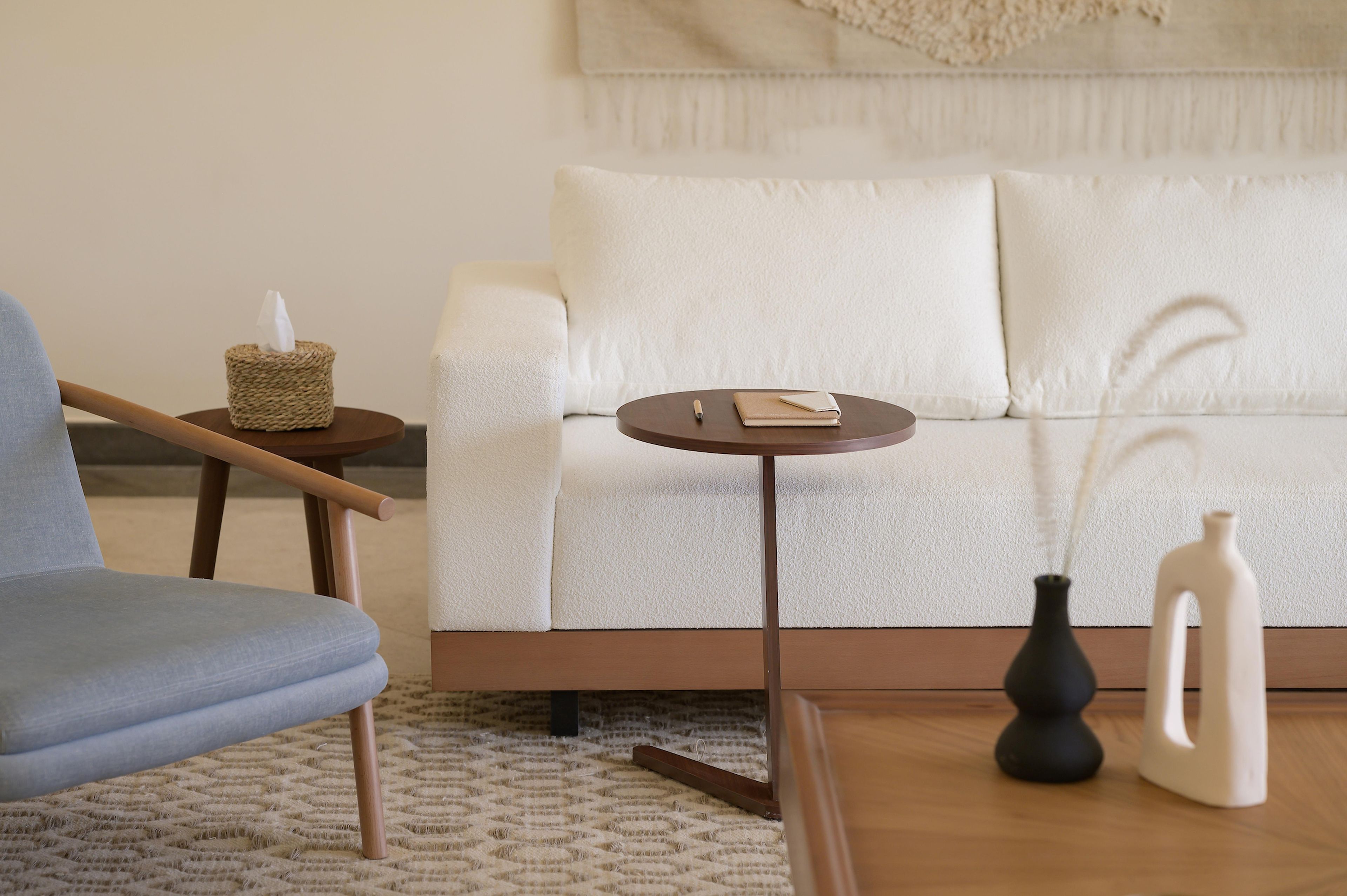 A modern living room with a sofa, a side table, a chair, and a coffee table.