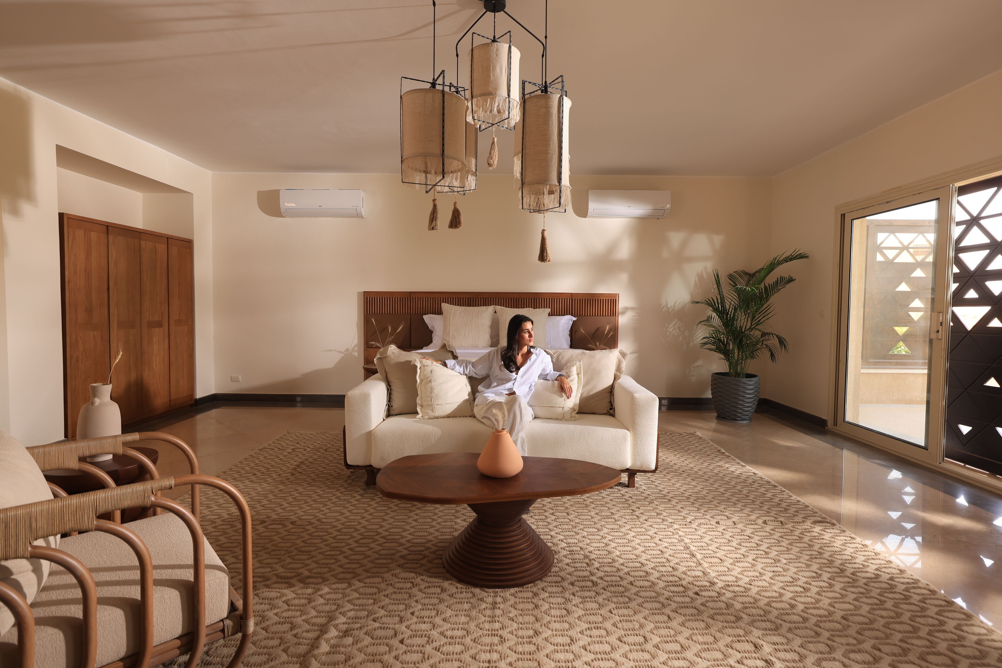 A spacious living area with a sofa, a coffee table, and a potted plant.