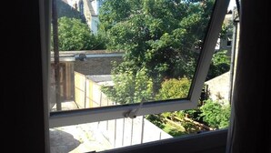 A view through a window with a metal frame, a brick wall, and greenery outside. - Haven House Hotel (Southend-on-Sea)