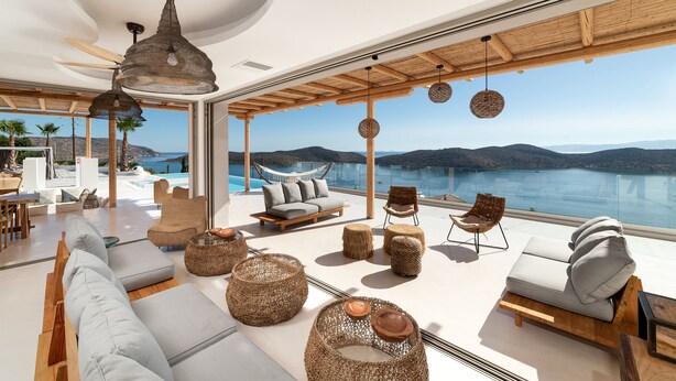 A modern, open-plan living area with a large window overlooking a scenic coastal view.