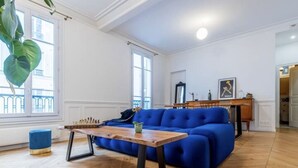 A living room with a blue sofa, wooden coffee table, and a chessboard.