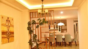 A dining area with a wooden partition, a potted plant, and a chandelier. - 5 Bedroom Exquisite Villa in Top-view Area (Addis Ababa)