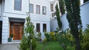 A courtyard with a wooden door, potted plants, and a small garden area. - 5 Bedroom Exquisite Villa in Top-view Area (Addis Ababa)