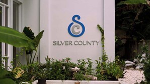 A building with a sign that reads "SILVER COUNTY" and a logo with a blue and gray design. - Silver County Fuvahmulah (Fuvahmulah)