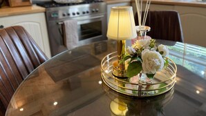 A dining table with a glass top, a lamp, and a decorative tray with flowers. - 'cosy Cottage' - 2 Bed High End Cottage in Bawtry (Doncaster)