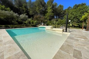 Relax by the serene pool surrounded by lush greenery.