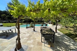 Relax by the pool surrounded by lush greenery and a serene atmosphere.
