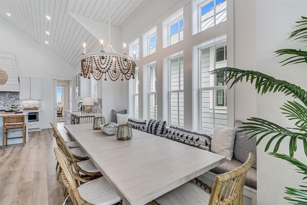 A spacious dining area with a long table, wicker chairs, and a decorative chandelier. - Spacious, Pet-Friendly, Home w/Access to Pools &More Amenities Cinnamon Shore (Port Aransas)