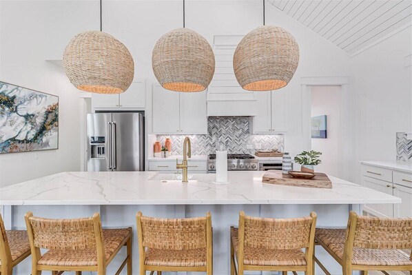A modern kitchen with a large island, stainless steel appliances, and wicker pendant lighting. - Spacious, Pet-Friendly, Home w/Access to Pools &More Amenities Cinnamon Shore (Port Aransas)