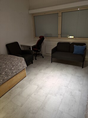 A bedroom with a bed, a desk, a chair, a sofa, and a radiator. - Pet-friendly 4 Bed Apt in Turku With Park Views (Turku)