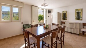 Un comedor con mesa y sillas de madera, un refrigerador y un armario.