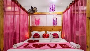A bed with pink curtains, heart-shaped decorations, and pillows with the word "magical."