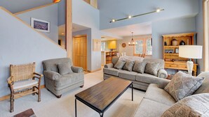 A spacious living room with a high ceiling, a staircase, and a cozy seating area with sofas and a coffee table. - The Baldy Traverse Retreat ski-in/out to Snowbird complimentary shuttle to Alta (Snowbird)